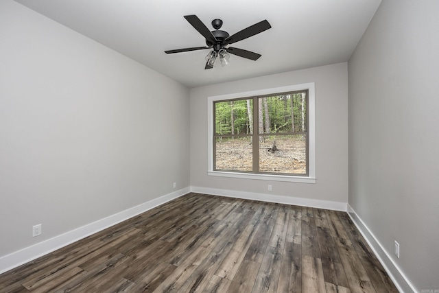 empty room featuring ceiling fan, baseboards, and dark wood-type flooring