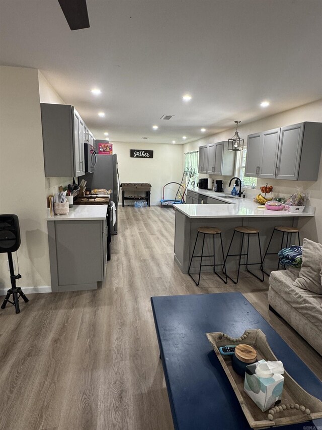 living room featuring visible vents, light wood-type flooring, recessed lighting, and baseboards
