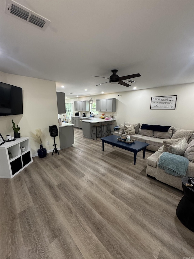 living area featuring recessed lighting, a ceiling fan, visible vents, and wood finished floors