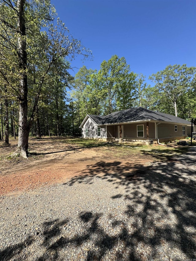 view of home's exterior featuring a porch and dirt driveway