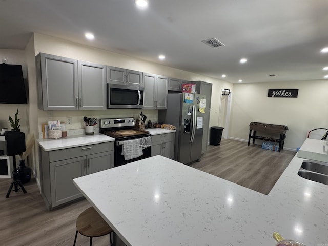 kitchen with gray cabinetry, visible vents, and stainless steel appliances