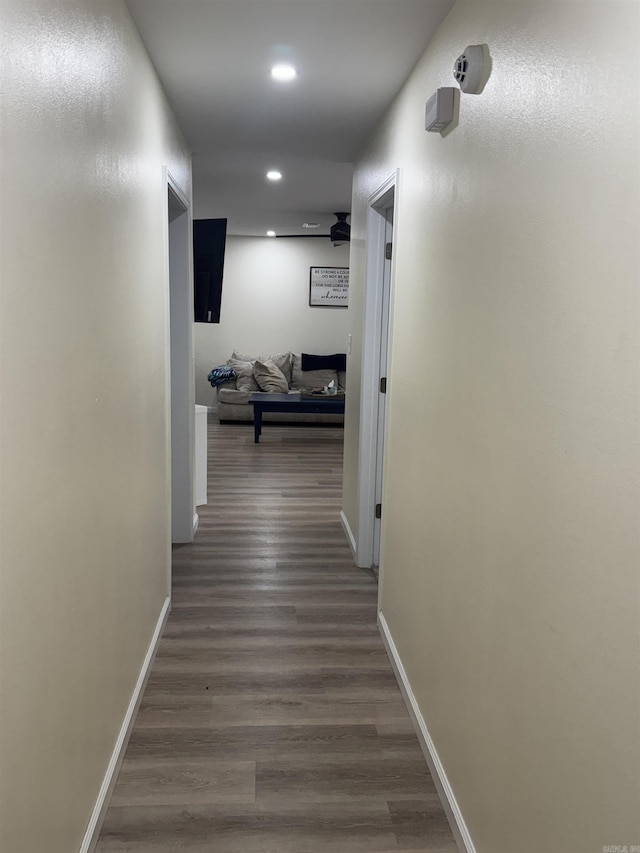 corridor with baseboards, recessed lighting, and wood finished floors