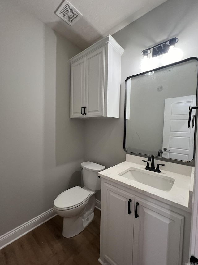 4406 Magee Dr, Texarkana, AR 71854 - bathroom featuring visible vents, baseboards, toilet, wood finished floors, and vanity