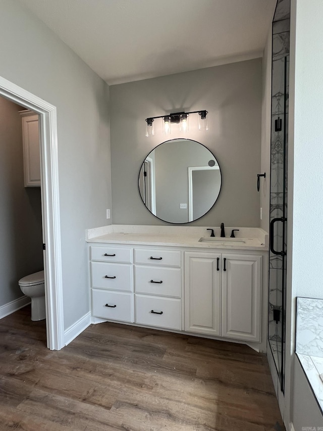 4406 Magee Dr, Texarkana, AR 71854 - full bathroom featuring wood finished floors, toilet, vanity, baseboards, and a stall shower