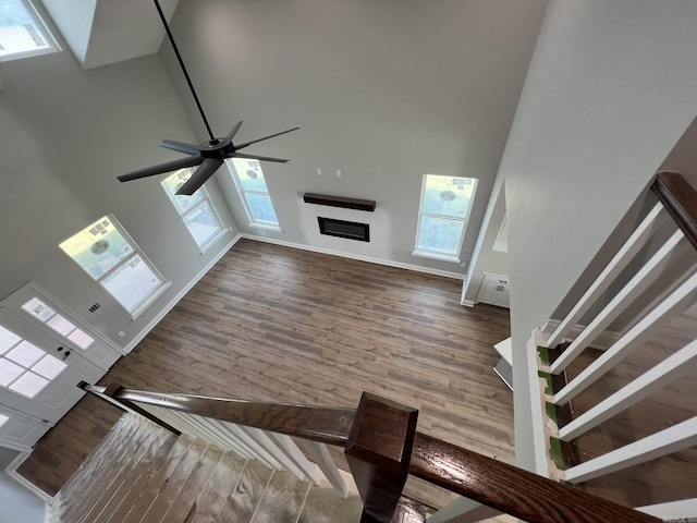 4406 Magee Dr, Texarkana, AR 71854 - unfurnished living room with baseboards, wood finished floors, ceiling fan, and a towering ceiling