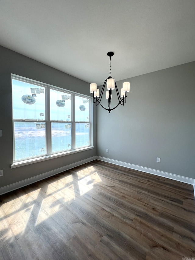 4406 Magee Dr, Texarkana, AR 71854 - unfurnished dining area with dark wood-style flooring, a notable chandelier, and baseboards