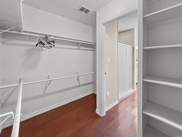 walk in closet with visible vents and wood finished floors