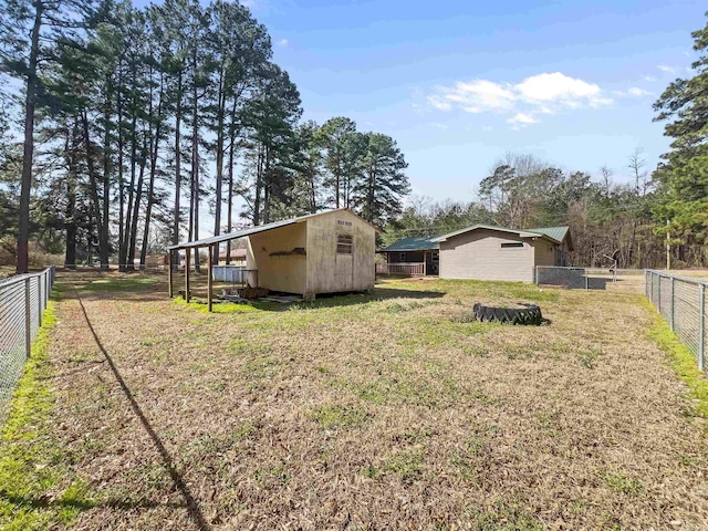 view of yard with an outdoor structure, a fenced backyard, and a storage shed