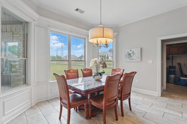 dining room with crown molding, an inviting chandelier, and visible vents