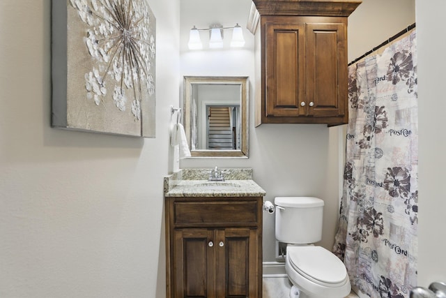 bathroom with toilet, vanity, and a shower with shower curtain