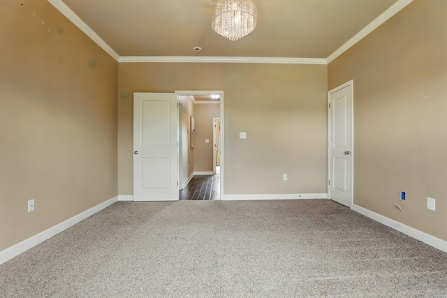 empty room featuring carpet, crown molding, and baseboards