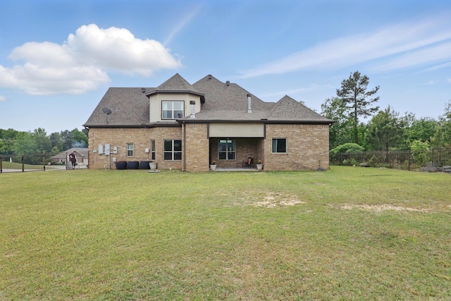 back of property featuring brick siding, fence, a yard, and a patio area