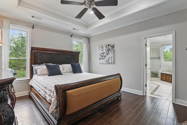 bedroom with ornamental molding, baseboards, visible vents, dark wood-type flooring, and a tray ceiling