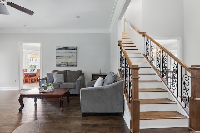 living area with wood finished floors, a ceiling fan, and crown molding