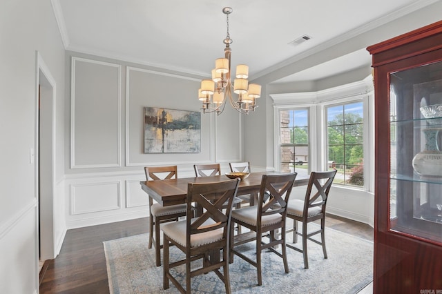dining area featuring a notable chandelier, dark wood-type flooring, visible vents, a decorative wall, and ornamental molding