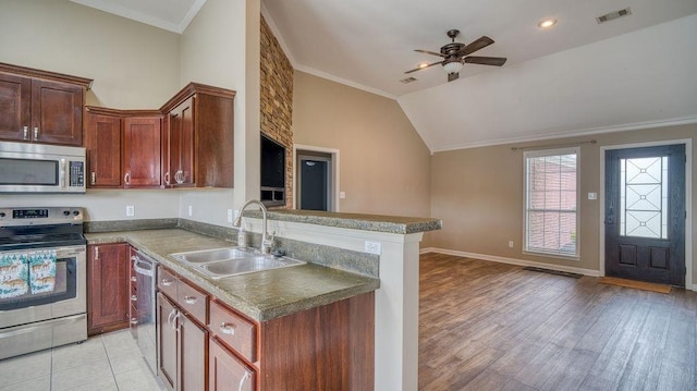 kitchen featuring a sink, stainless steel appliances, a ceiling fan, visible vents, and a peninsula