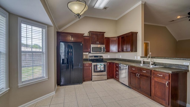 kitchen with stainless steel appliances, vaulted ceiling, dark countertops, a sink, and light tile patterned flooring