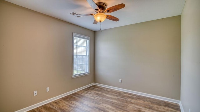 spare room featuring baseboards, wood finished floors, and ceiling fan