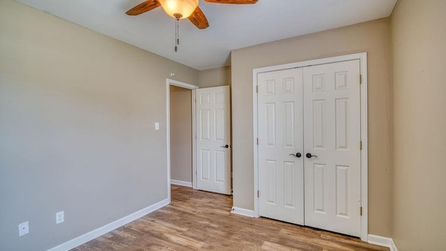 unfurnished bedroom featuring wood finished floors, ceiling fan, a closet, and baseboards