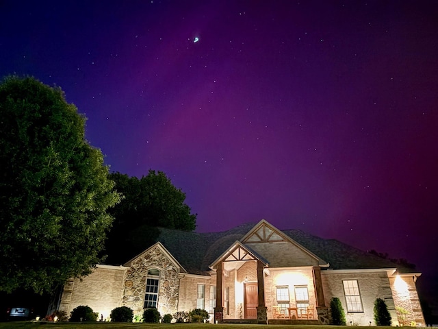 view of front of home with a yard and stone siding