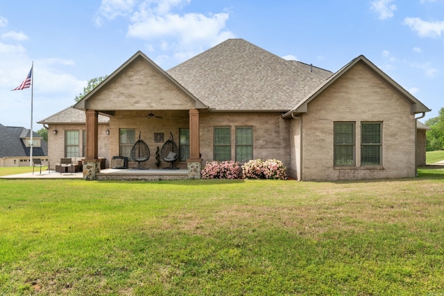 view of front of property with a patio, a shingled roof, a ceiling fan, and a front yard