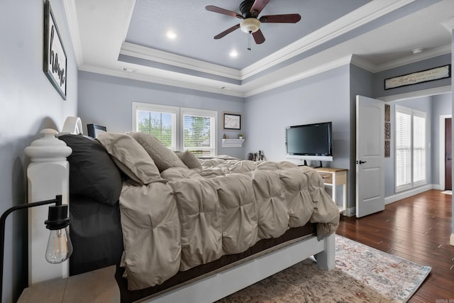 bedroom with dark wood finished floors, visible vents, ornamental molding, and a tray ceiling