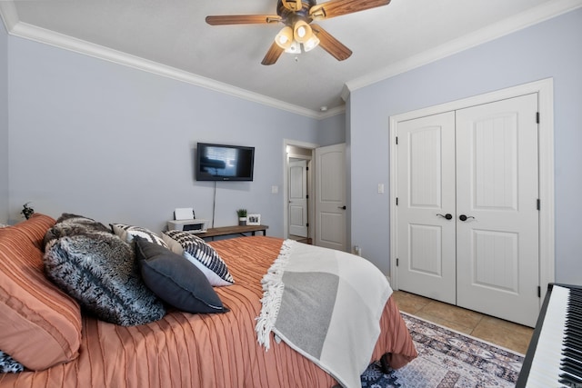 bedroom with light tile patterned floors, a ceiling fan, a closet, and crown molding