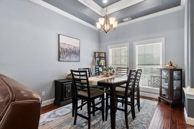 dining room with wood finished floors, a chandelier, crown molding, and a tray ceiling