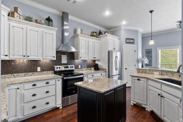 kitchen with stainless steel appliances, white cabinets, a sink, wall chimney exhaust hood, and crown molding