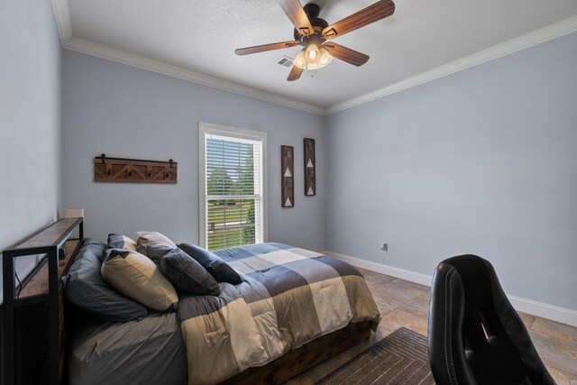 bedroom featuring stone tile floors, ornamental molding, and baseboards