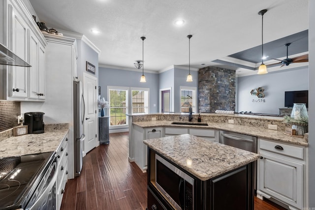 kitchen featuring crown molding, a sink, a kitchen island, and stainless steel appliances
