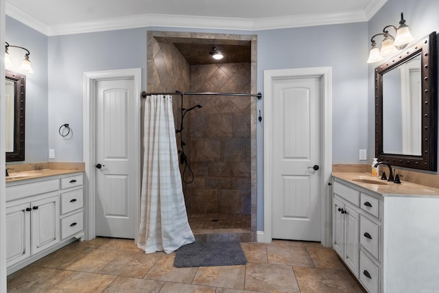full bathroom with two vanities, crown molding, tiled shower, and a sink