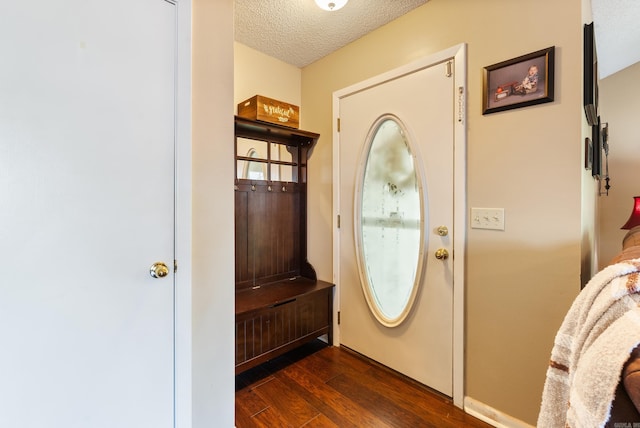interior space featuring dark wood-style floors, a textured ceiling, and baseboards