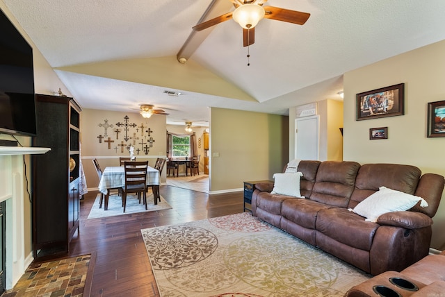 living room featuring vaulted ceiling with beams, a ceiling fan, a textured ceiling, and dark wood-type flooring
