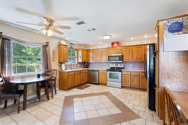 kitchen featuring appliances with stainless steel finishes, light countertops, visible vents, a ceiling fan, and a textured ceiling