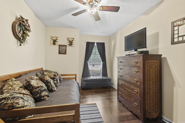 bedroom featuring a textured ceiling, wood finished floors, a ceiling fan, and baseboards
