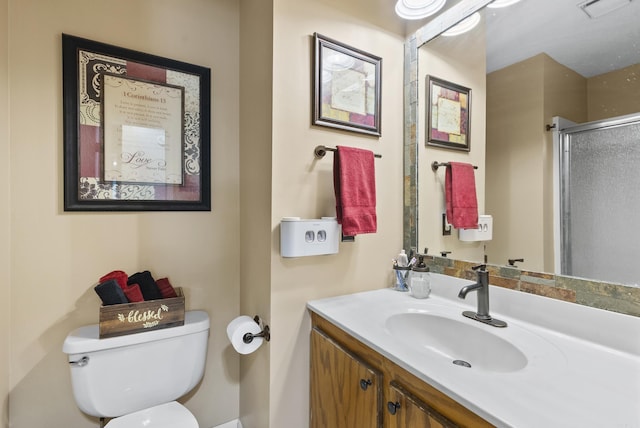 bathroom featuring visible vents, a stall shower, toilet, and vanity