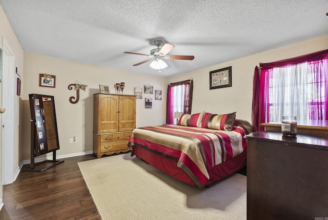 bedroom with a textured ceiling, ceiling fan, baseboards, and dark wood-type flooring