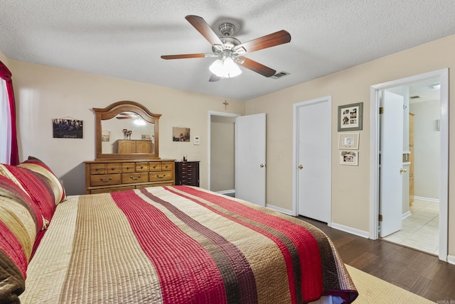 bedroom featuring a textured ceiling, visible vents, ceiling fan, and wood finished floors