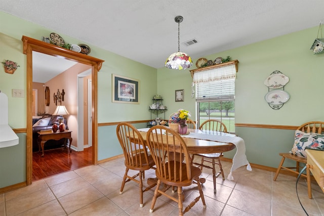 dining room with visible vents, a textured ceiling, and light tile patterned flooring