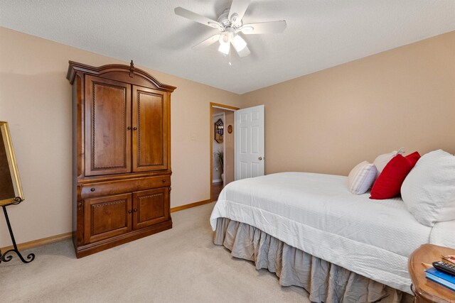 bedroom featuring ceiling fan, light colored carpet, and baseboards