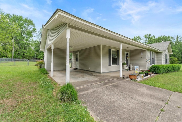 view of front of property featuring fence, a carport, a front yard, and concrete driveway