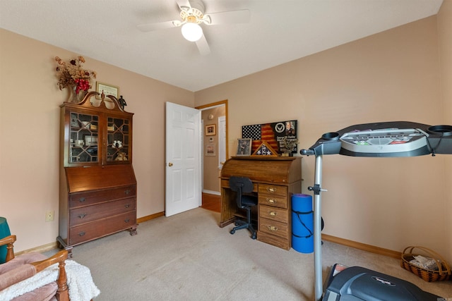 carpeted office with baseboards and a ceiling fan