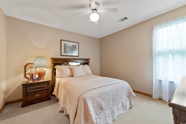 bedroom featuring a ceiling fan, visible vents, light carpet, and baseboards