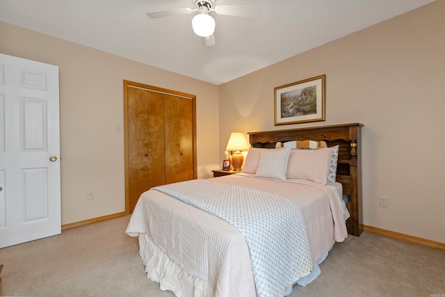 bedroom featuring a closet, a ceiling fan, light carpet, and baseboards