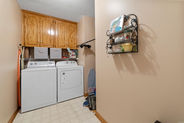 laundry room featuring cabinet space, independent washer and dryer, baseboards, a textured ceiling, and light floors
