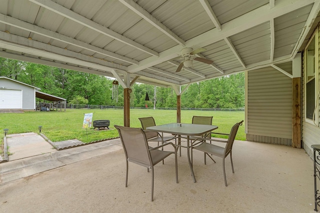 view of patio / terrace featuring an outdoor structure, a fenced backyard, ceiling fan, and outdoor dining area