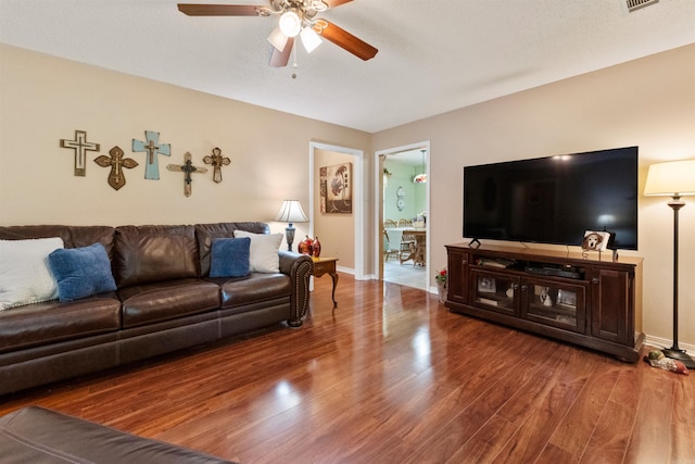living area featuring a ceiling fan, wood finished floors, and baseboards