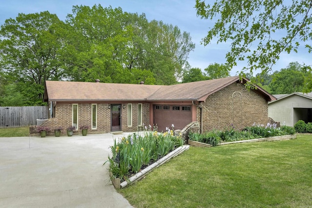 ranch-style home featuring brick siding, fence, driveway, a front yard, and an attached garage