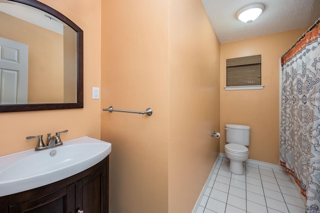 bathroom featuring vanity, toilet, a textured ceiling, baseboards, and tile patterned flooring
